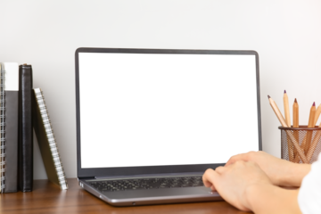 Female hands using laptop with blank screen in working place, minimalistic inerior, copy space