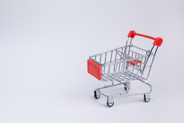 Close up red supermarket cart on white background. Online shopping, e-commerce, spending money concept. Shopping service on The online web. offers home delivery. free space for advertising