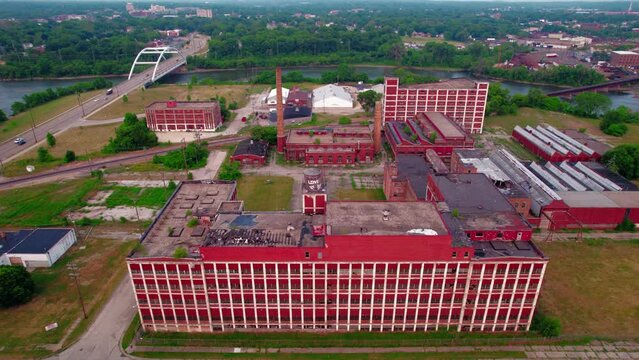 lowering aerial of a Dramatic Red abandoned building with a strong symmetry and pattern. Cinematic aerial with broken windows of Barber Colman. 4k Rockford, Illinois, USA