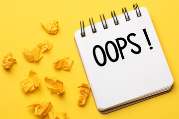 The words Oops with a black marker in a notebook on a yellow background .. Apologies for a minor...