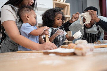 Happy African American father and Asia mother with daughter and son cooking break or bakery at kitchen at home	