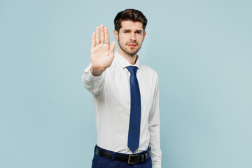 Young dissatisfied sad employee business man corporate lawyer wear classic formal shirt tie work in office show stop gesture with palm isolated on plain pastel light blue background studio portrait