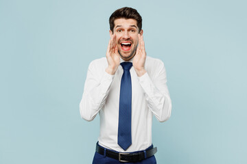 Young employee business man corporate lawyer wear classic formal shirt tie work in office scream sharing hot news about sales discount with hands near mouth isolated on plain blue background studio.