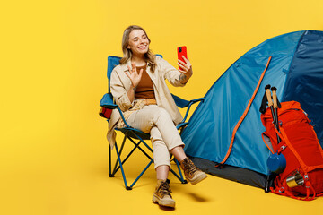 Full body young woman sit near bag stuff tent do selfie shot mobile cell phone isolated on plain...