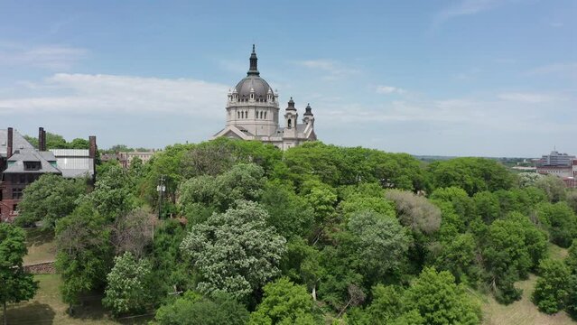 Aerial rising shot over the treetops to reveal the massive Cathedral of Saint Paul in Minnesota. 4K