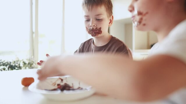 baby boy and girl eat chocolate. dirty little baby kids in the kitchen eating chocolate in lifestyle the morning. happy family eating sweets kid dream concept. baby dirty face eating chocolate cocoa