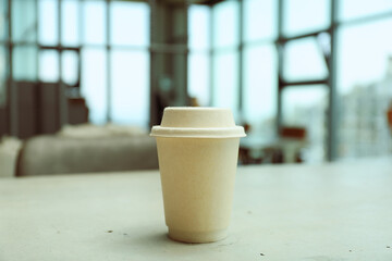 A cup of coffee on the table near the window
