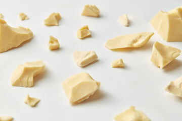 Homemade white chocolate chunks on plain background.