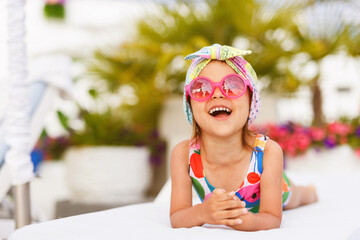 Funny cute baby girl on summer vacation. Child having fun in swimming pool. Sweet toddler girl in...