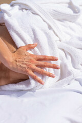 Woman having relax in tropical massage spa on the beach near the sea on massage table. Professional masseur provides neck, face and chest spa procedures.