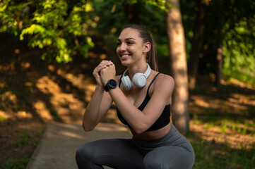 Fit sport girl doing squat exercise outdoor in park, during sunny summer day