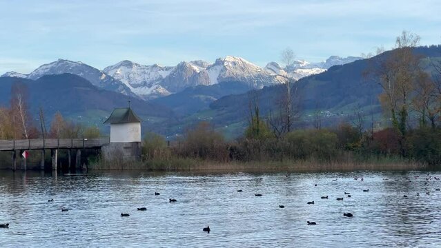 Historical wooden pedestrian bridge and its medieval Chappel (Heilig H&uuml;sli) crossing the Upper Zurich lake, Rapperswil, St. Gallen, Switzerland. A UNESCO World Heritage Site