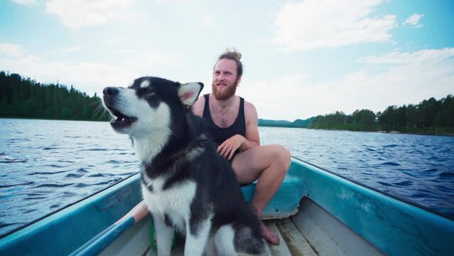 Caucasian Guy Boating With His Alaskan Malamute. POV