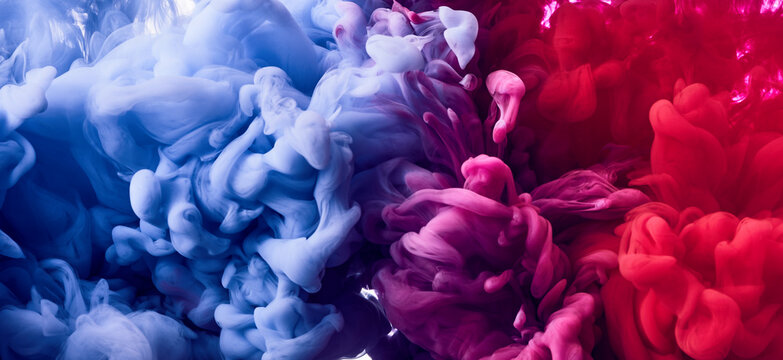 Splash of blue and pink paint in water over white background