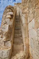 Narrow and steep stone staircase in the wall of a medieval castle