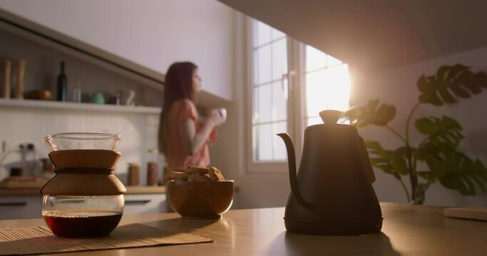 Woman walk and look out to window with coffee cup mug. Concept morning breakfast