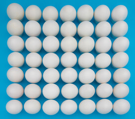 A large number of white eggs on a blue background