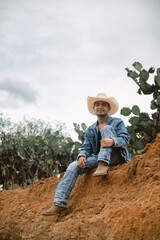 Cowboy under the vast sky, surrounded by cacti, working on a farm