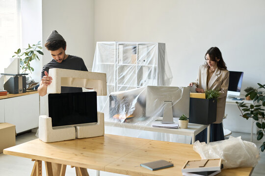 Young business people packing things during the move in other office