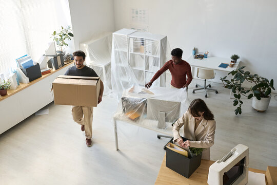 High angle view of business people packing things and furniture while moving in new office