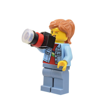 Lego  minifigure photograph is taking a picture, funny and cheerful face grimace. Editorial illustrative image of popular children plastic toy.