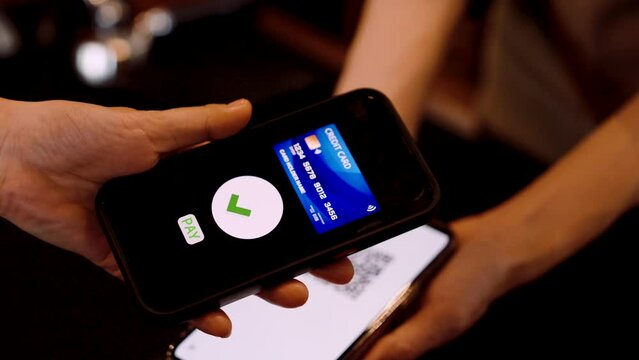 Cafe worker lodge on phone with QR code for payment account, customers who want pay by transfer payment, credit card payment by scanning QR code, when payment is completed, page will show check mark.
