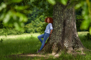 Redhead curly hair woman in a forest