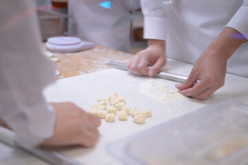 Hands of a young woman in an apron holding a rolling pin on a table. ,Create the dough, baking, baking ideas, homemade bakery. shooting while moving