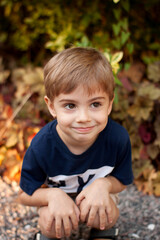 The boy is sitting with a smile on his face