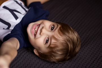 Portrait of a boy lying on a bed at home
