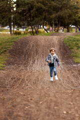 A boy runs along the road in the park