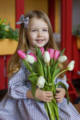 a girl in a dress with tulips in her hands