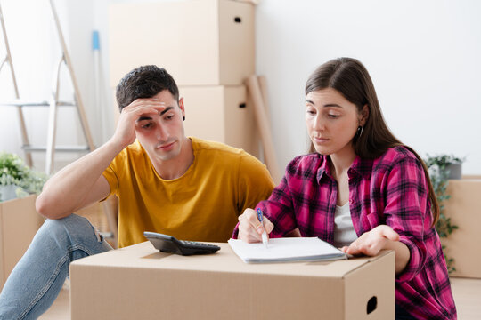 Young couple calculating outlay in new home