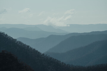 Blue mountain layers through the valley at Kanangra Walls Lookout on a sunny day