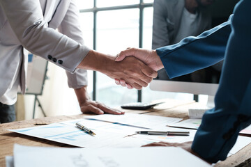 Handshake as successful negotiation ending, close-up. Unknown business people shaking hands after contract signing in modern office
