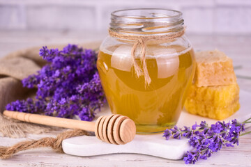 A jar of lavender honey and mixing lavender flowers.
