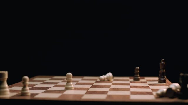 Caucasian Woman's Hand Knocking Down Chess Pieces on Rotating Chess Board. Shot with ARRI Alexa in ArriRaw at 120 fps, exported 23.98 fps QuickTime Apple ProRes 422 HQ.