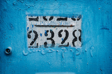 Vibrant blue house post: Numbers adorn this eye-catching house post, creating an intriguing focal point against the vivid blue backdrop.