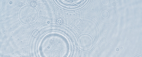 raindrop circles in sunshine from above on transparent water background, concept banner for beauty...