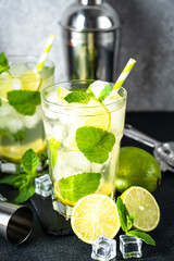 Mojito with rum and lime on black background. Tradition Summer drink with ice.