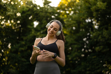 Sport girl with headphones listening to music while prepairing for outdoors workout