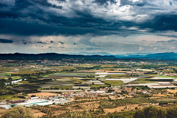 Vue panoramique  avec ciel d'orage sur la région de l'Emporda (Espagne) et sur le village de Torroella de Montgrí dans la province de Gérone. - 615760608