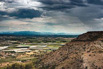 Vue panoramique  avec ciel d'orage sur la région de l'Emporda (Espagne) et sur le village de Torroella de Montgrí dans la province de Gérone. - 615760669