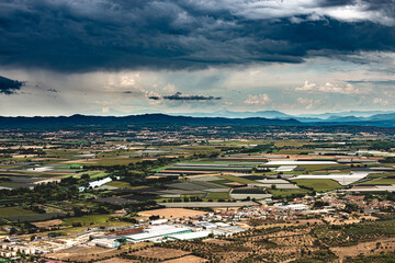 Vue panoramique  avec ciel d'orage sur la région de l'Emporda (Espagne) et sur le village de Torroella de Montgrí dans la province de Gérone. - 615760846