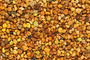 Background of multicolor grains of bee pollen, top view. Heap of bee pollen, texture.
