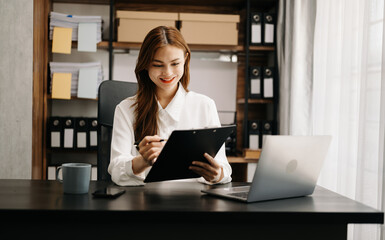 Confident business expert attractive smiling young woman holding digital tablet  on desk in creative office.