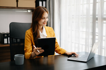 Confident business expert attractive smiling young woman holding digital tablet  on desk in creative office.