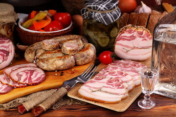 Snack slicing smoked brisket served on wooden board and homemade sausage