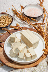 Fresh Tofu cheese with soybeans. Cube pieces, healthy ingredient for vegan lifestyle, modern stand