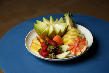 Mixed fruit platter with strawberries, melon, pineapple, peaches and grape